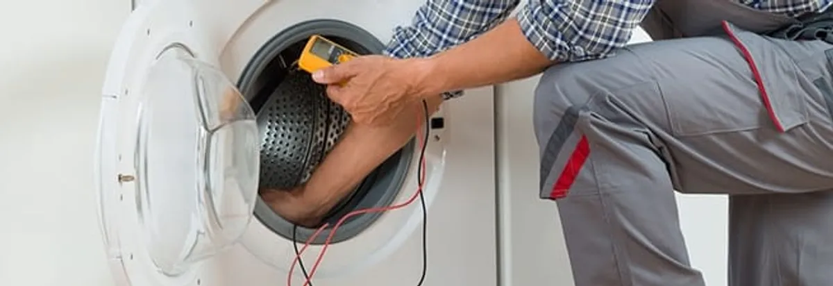 Dryer repair technician inspecting and repairing a clothes dryer in Pittsburgh, PA