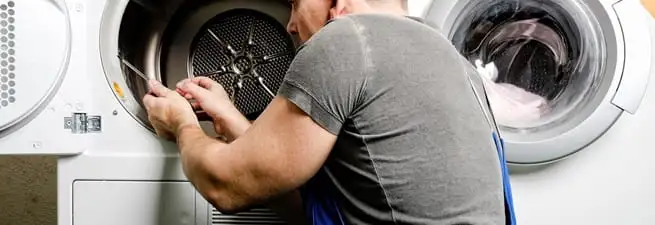 Dryer repair technician fixing a clothes dryer drum in Pittsburgh, PA