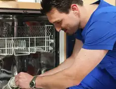Dishwasher repair technician inspecting and servicing an open dishwasher in Pittsburgh, PA