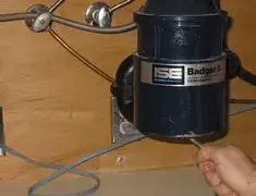 Garbage disposal repair technician tightening the mounting ring under a sink in Pittsburgh, PA