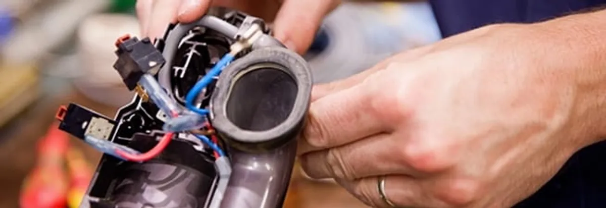 Vacuum repair technician reconnecting wiring and components in Pittsburgh, PA