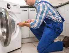 Washing machine repair technician servicing a front-load washer in Pittsburgh, PA