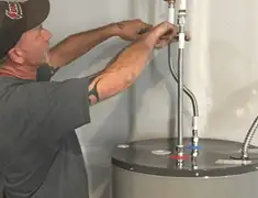 Water heater repair technician tightening supply line connections in Pittsburgh, PA
