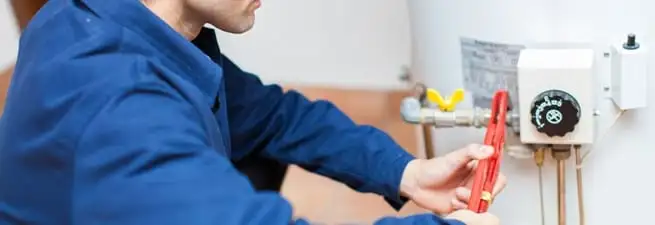 Water heater repair technician adjusting the temperature control and gas valve in Pittsburgh, PA